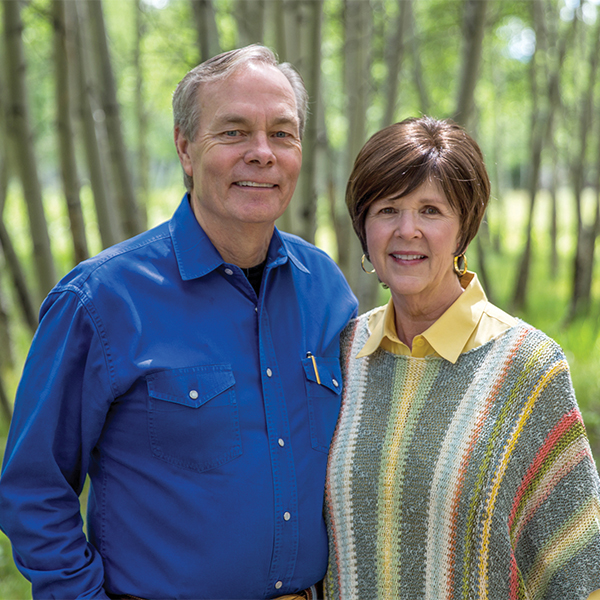 A picture of Andrew standing with his wife Jamie.